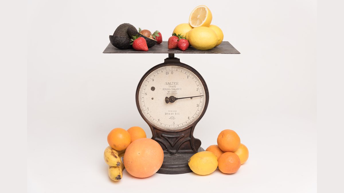 A set of vintage kitchen scales weighing fresh fruit