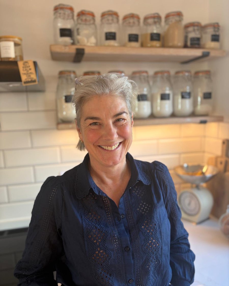 Vicky in her kitchen, with storage jars and scales behind her